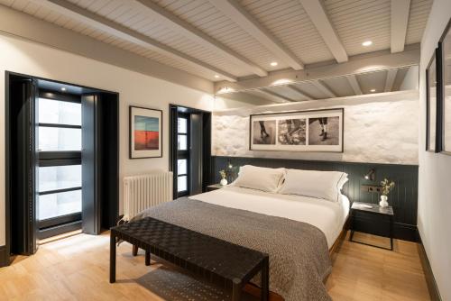 ein Schlafzimmer mit einem Bett und einer Bank darin in der Unterkunft housingcoruña ART in A Coruña