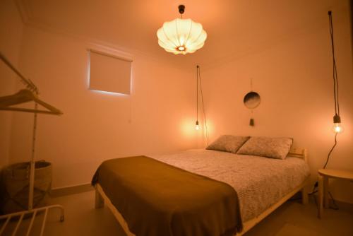 a bedroom with a bed and a light fixture at Cimo do Monte - casa rústica na aldeia in Vila Nova de Foz Coa