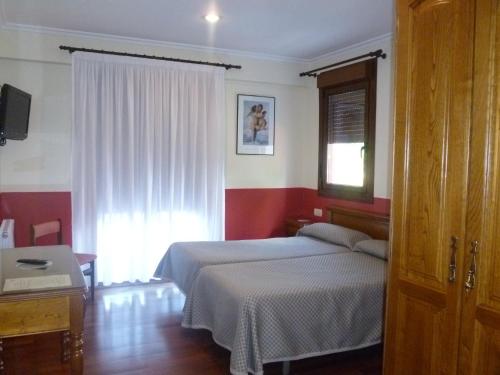 a bedroom with a bed and a window at Hotel Leku Eder in Donostia-San Sebastián