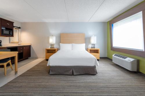 Holiday Inn Express & Suites Wheat Ridge-Denver West, an IHG Hotel في ويت ريدج: غرفه فندقيه بسرير ومطبخ