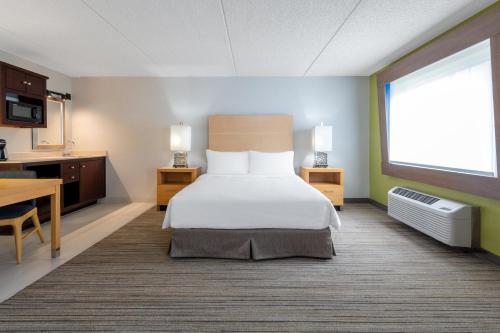 a hotel room with a bed and a kitchen at Holiday Inn Express & Suites Wheat Ridge-Denver West by IHG in Wheat Ridge