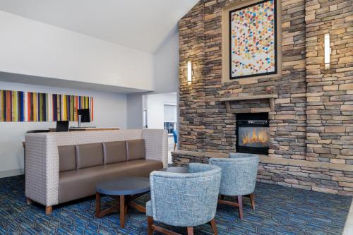 a lobby with a couch and chairs and a fireplace at Holiday Inn Express & Suites Wheat Ridge-Denver West by IHG in Wheat Ridge