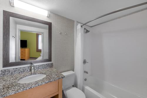 Holiday Inn Express & Suites Wheat Ridge-Denver West, an IHG Hotel في ويت ريدج: حمام مع حوض ومرآة