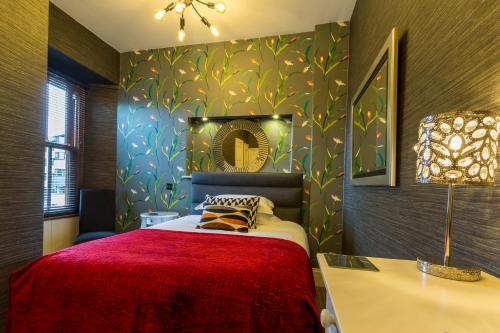 a bedroom with a bed with a red blanket at Jerichos Boutique Accommodation in Windermere