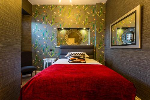 a bedroom with a large bed with a red blanket at Jerichos Boutique Accommodation in Windermere