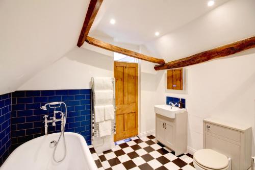 ein Badezimmer mit einem karierten Boden und einer Badewanne in der Unterkunft Green Parrot House in Devizes