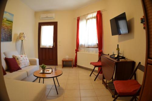 a living room with a couch and a tv at Liogerma apartments in Ierissos