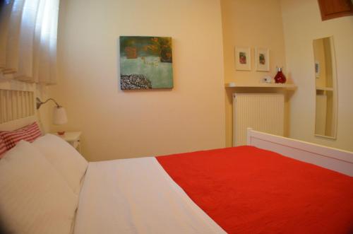 a bedroom with a bed with a red blanket at Liogerma apartments in Ierissos