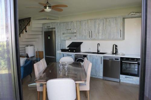una cucina con tavolo, sedie e ventilatore a soffitto di Riverside villas a Ortaca