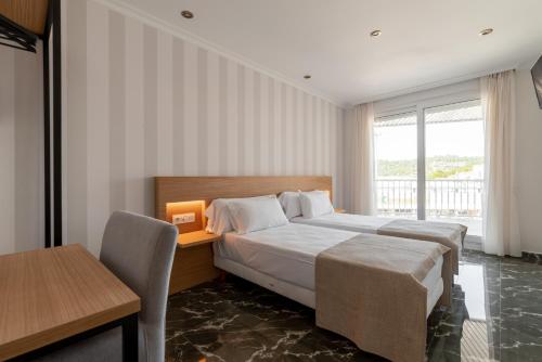 1 dormitorio con cama, escritorio y ventana en Hotel Condado Ourense en Ourense