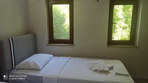 un letto in una camera da letto con due finestre di Riverside villas a Ortaca