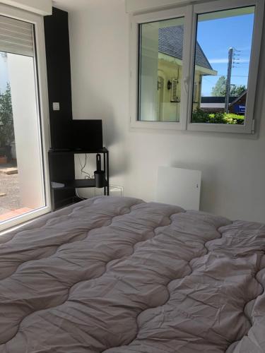 een bed in een slaapkamer met een groot raam bij Dar Lila Cote d'Opale in Saint-Martin-Boulogne