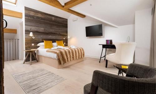 a bedroom with a bed with yellow pillows and a tv at Shepherd's View in Kendal