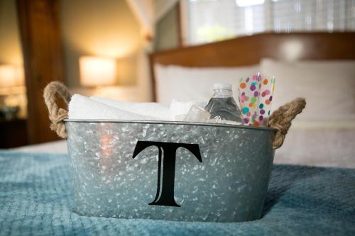 a metal bucket with a letter sitting on a bed at J Patrick Inn in Cambria