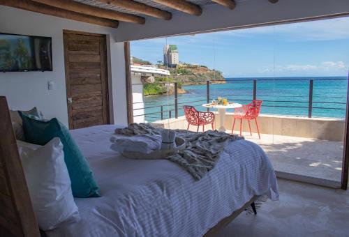 um quarto com uma cama e vista para o oceano em Aria By LD Hotel Boutique em Pampatar