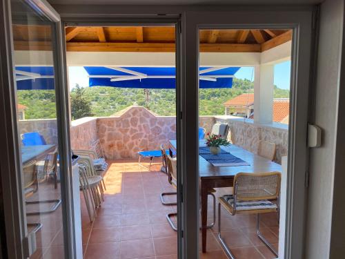 a patio with a table and chairs and blue umbrellas at Villa Mediterranea in Murter
