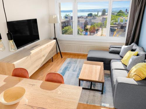 a living room with a couch and a flat screen tv at ARISER - Zug Lake View Business Apartment in Zug