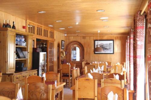 a dining room with wooden tables and chairs at Hôtel Bruxelles in Soldeu