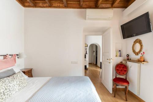 sypialnia z białym łóżkiem i czerwonym krzesłem w obiekcie iFlat Via del Corso Elegant Apartment w Rzymie
