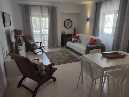a living room with a couch and a table and chairs at Dunas Mar in Alvor