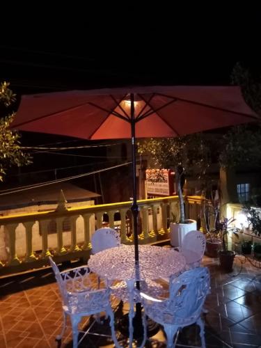 a table with two chairs and an umbrella at POSAD FAMILIAR EL PARAiSO in Xilitla