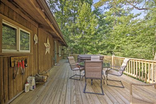 a wooden deck with a table and chairs on it at Secluded Stanardsville Cabin with 10 Acres and Hot Tub in Stanardsville