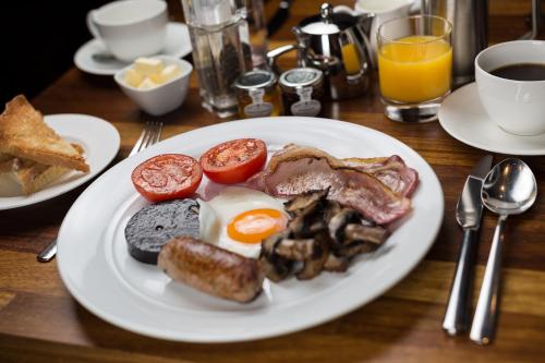a plate of breakfast food on a wooden table at Jerichos Boutique Accommodation in Windermere