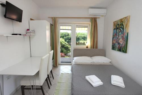 Zimmer mit einem Tisch, einem Bett und einem Schreibtisch in der Unterkunft Bozena Studio KNEB in Portorož