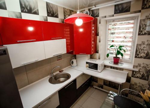 a small kitchen with red cabinets and a sink at Будинок для Відпочинку біля Фентезі Парка in Umanʼ