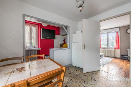 - une cuisine avec une table et un réfrigérateur dans la chambre dans l'établissement CHEZ MIMI, à Bourbon-Lancy
