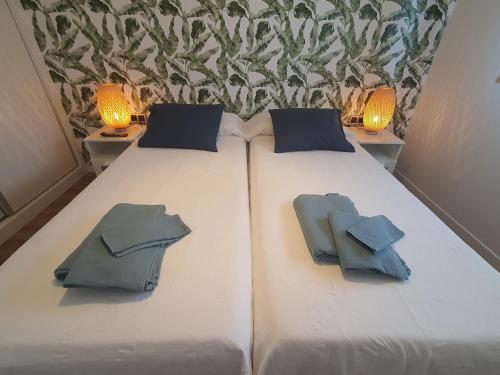 a bed with two pillows on it with two lamps at Sunset Waves Benidorm by KalmaRent in Benidorm