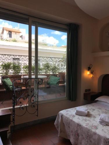 ein Schlafzimmer mit einem Fenster mit Blick auf einen Innenhof in der Unterkunft Hotel OKAPI in Rom