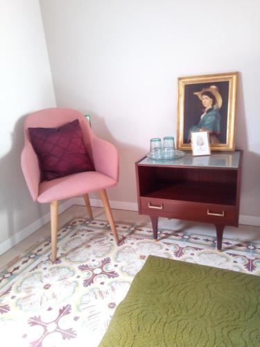 a living room with a chair and a dresser at Traditional Townhouse Central Malta - unique location in Luqa
