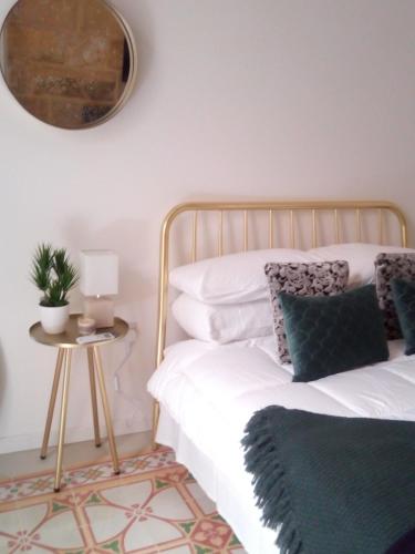 a bedroom with a bed and a table with a mirror at Traditional Townhouse Central Malta - unique location in Luqa