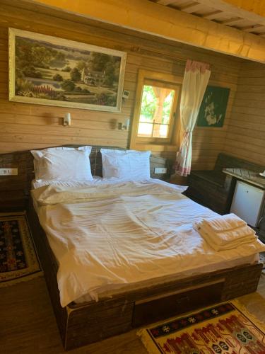 Căsuța Bunicilor في فيسيو دي جوس: غرفة نوم بسرير كبير مع شراشف بيضاء
