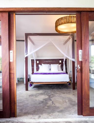 a bedroom with a bed with a canopy at Kite Soul Pousada in Cumbuco
