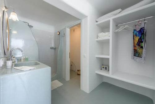 a white bathroom with a sink and a shower at Blu Suites and Studios in Adamas
