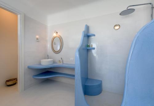 a bathroom with a blue sink and a mirror at Blu Suites and Studios in Adamas
