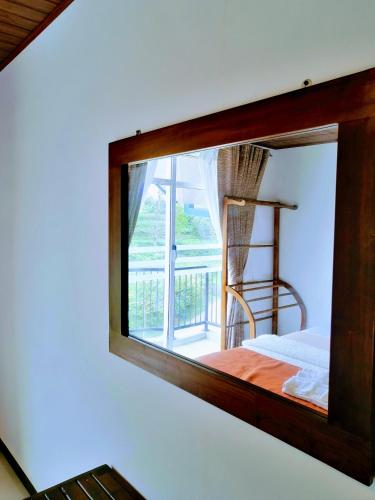 a mirror reflecting a room with a bed and a balcony at Moon Plains Luxury Apartments in Nuwara Eliya