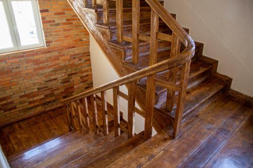 a wooden staircase in a room with a brick wall at Pokoje Śródmieście in Bydgoszcz