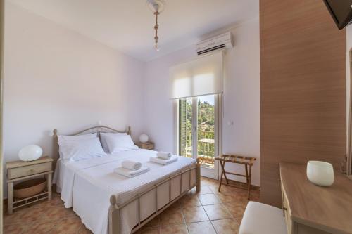1 dormitorio con cama, escritorio y ventana en Nysa Residence en Ándros