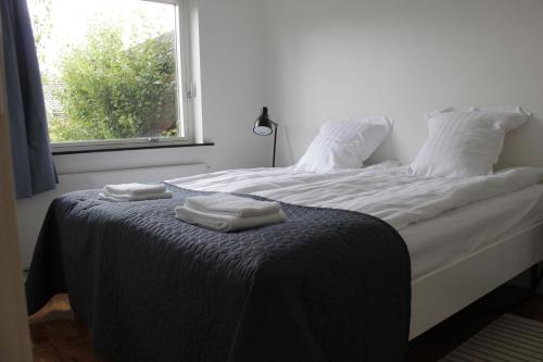 a bedroom with a bed with two towels on it at Villa Hassel in Middelfart