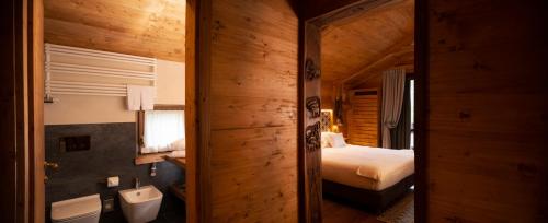 a bathroom with a bed and a sink in a room at Gran Baita Hotel & Wellness in Courmayeur