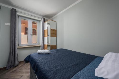 a bedroom with a blue bed and a window at Premium Apartment Daka in Poreč