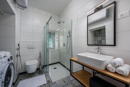 a bathroom with a sink and a washing machine at Premium Apartment Daka in Poreč