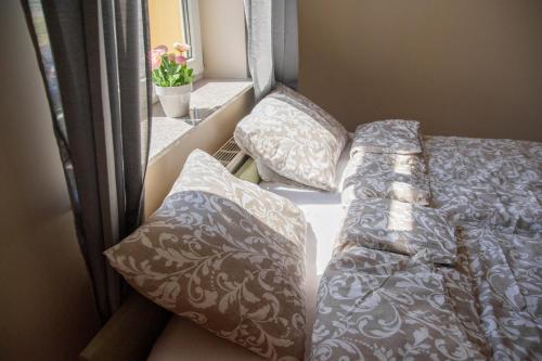 a bed and pillows in a small room with a window at Pokoje Śródmieście in Bydgoszcz