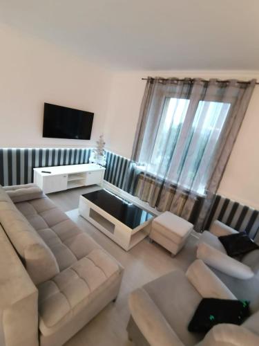 a living room with a couch and a flat screen tv at Apartament Francuski in Krosno