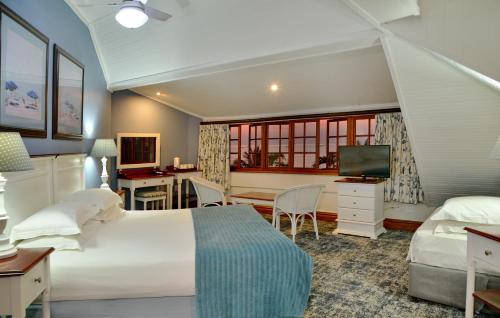 Pumula Beach Hotel في Umzumbe: غرفة نوم بسرير ومكتب وتلفزيون
