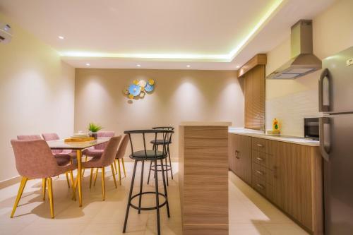 a kitchen and dining room with a table and chairs at The Address Palace Apartments in Dammam