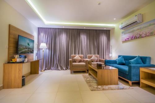a living room with a blue couch and a chair at The Address Palace Apartments in Dammam